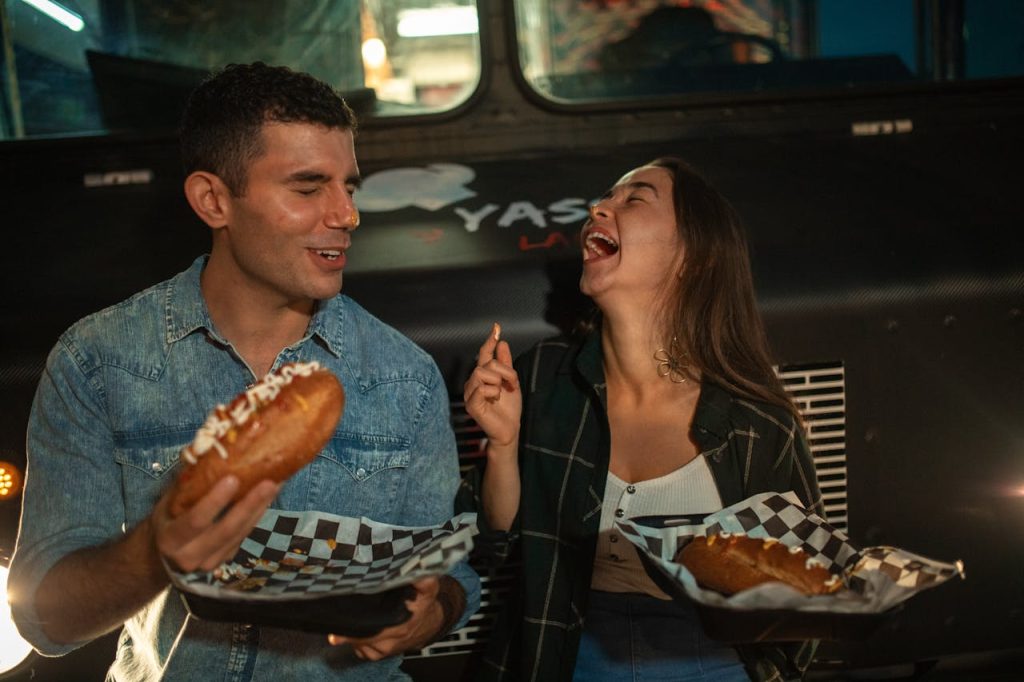 Couple laughing and enjoying food together, representing the genuine connection created through mindful dating for men.