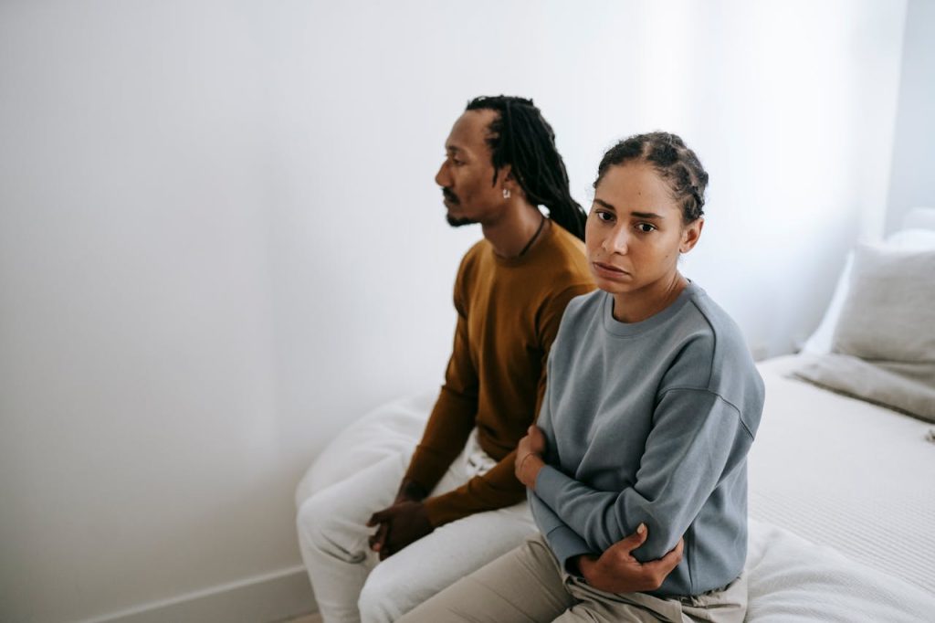 Couple sitting apart in silence, showing how untreated mental health struggles can damage communication and relationships.