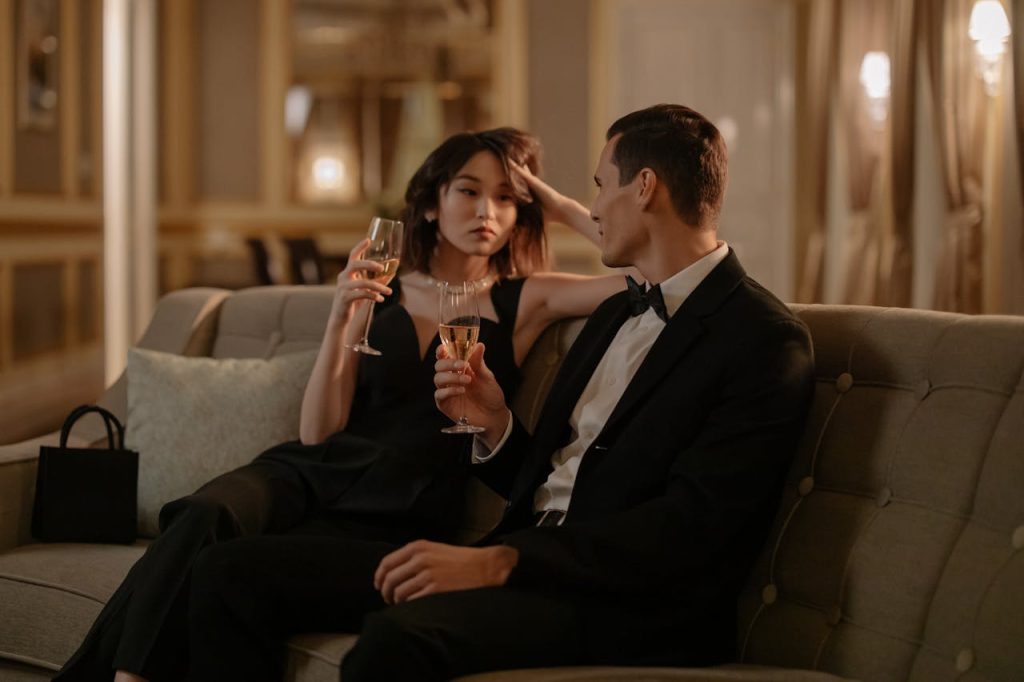 Man in a tuxedo having an engaged conversation with a woman while sharing drinks, illustrating how unplugging improves presence and connection.