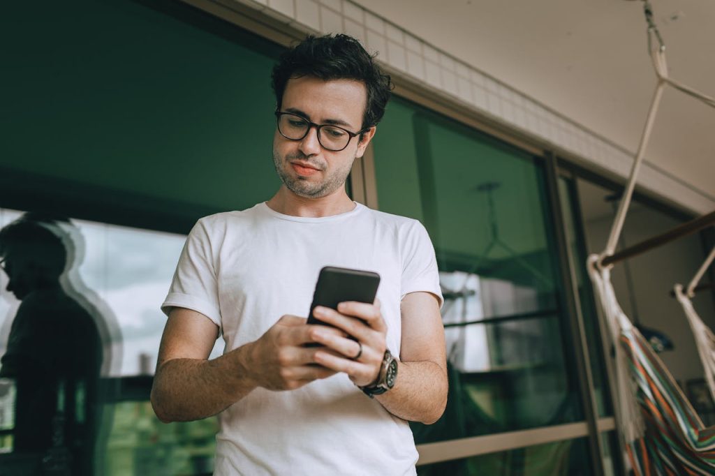 Man swiping through a dating app with a detached expression, illustrating the numbers-game approach to dating.
