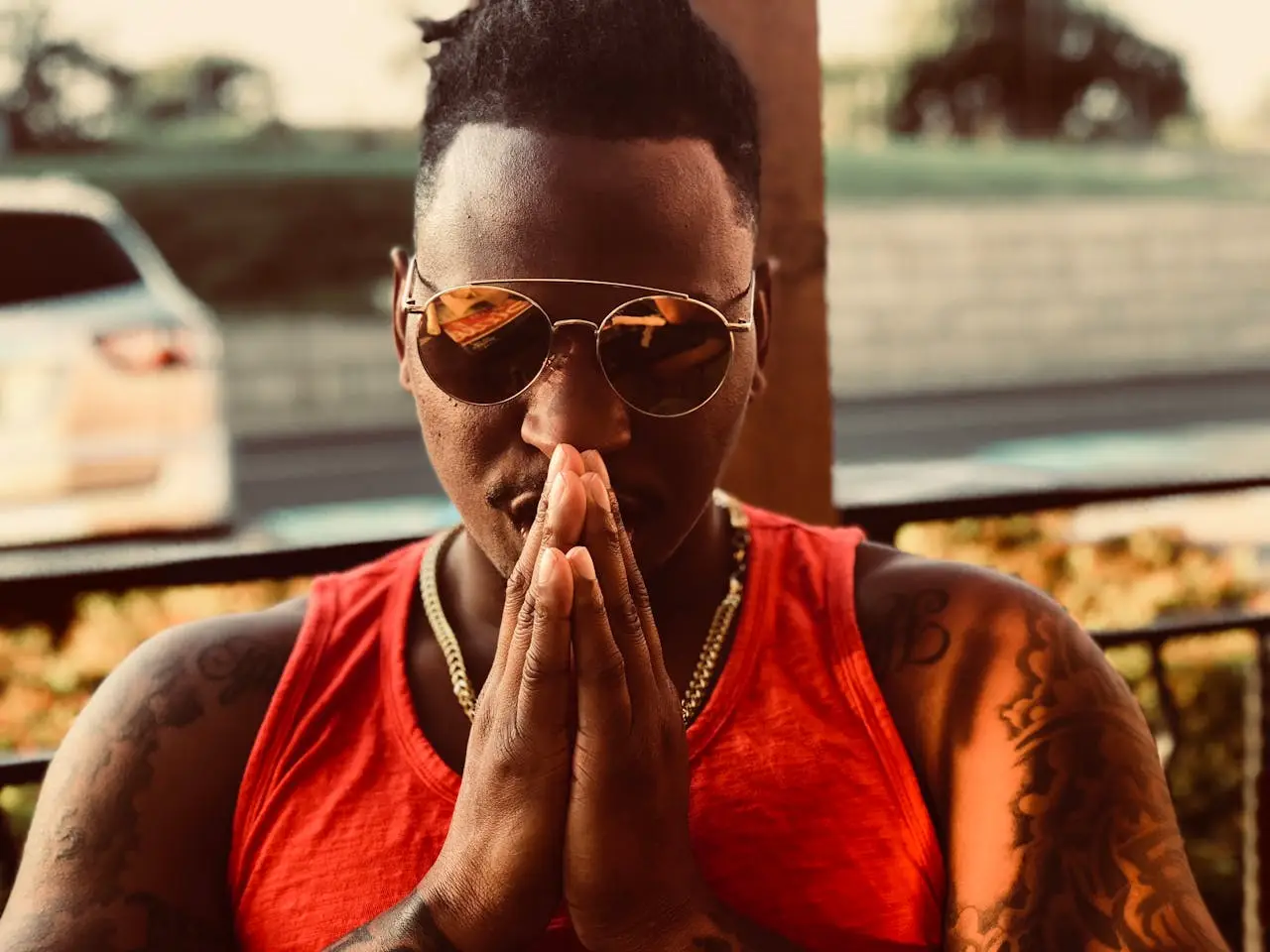 Man with hands pressed together in a calm posture, symbolizing grounded strength, inner peace, and the principle of not being against anyone.