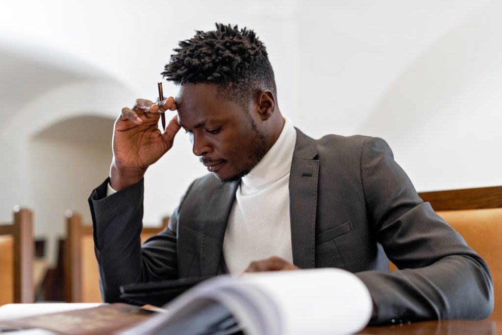 Worried man reviewing financial documents, representing how cost concerns become a barrier that prevents men from seeking therapy.