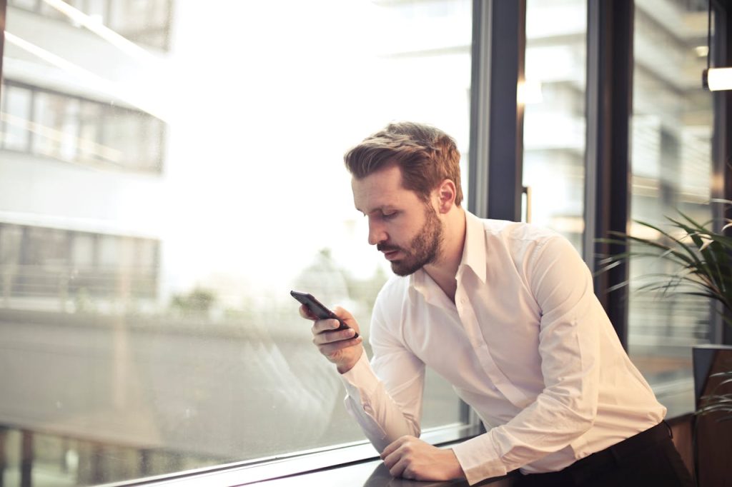 Man confidently texting on his phone, representing honest communication in mindful dating for men.