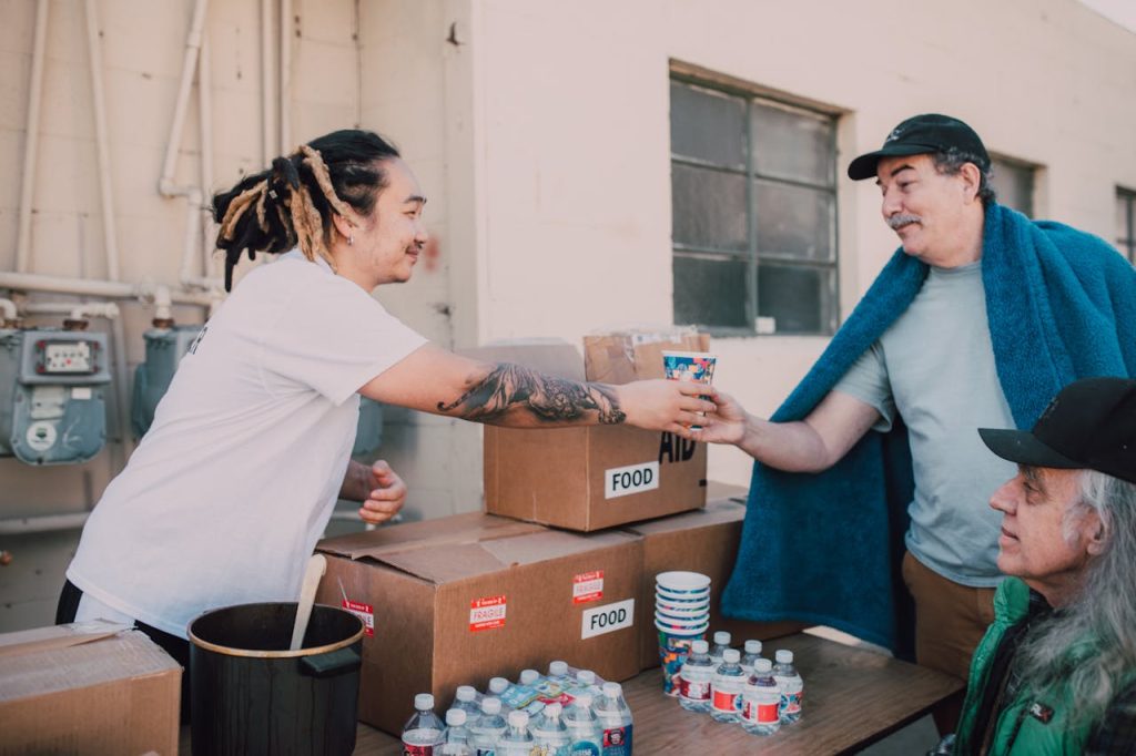 A man volunteering at a community food drive, offering assistance and support to others as an expression of healthy masculinity.