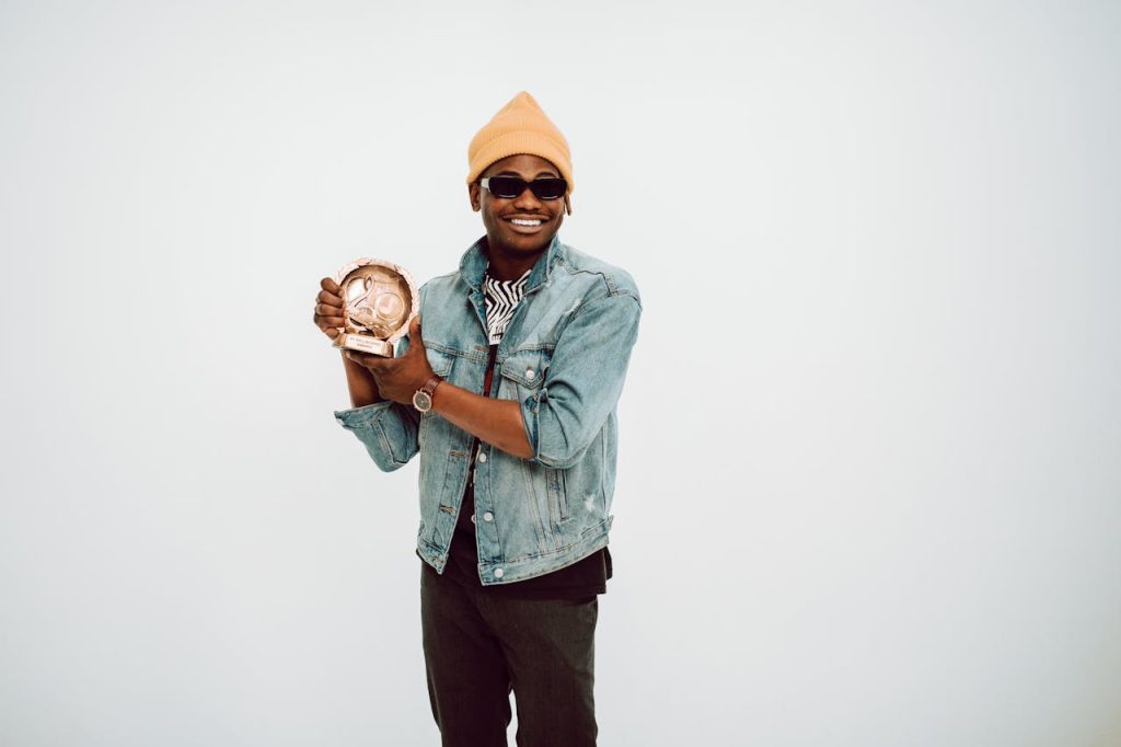 Man holding a unique artistic trophy, symbolizing self-defined success and personal achievement grounded in a personal philosophy.