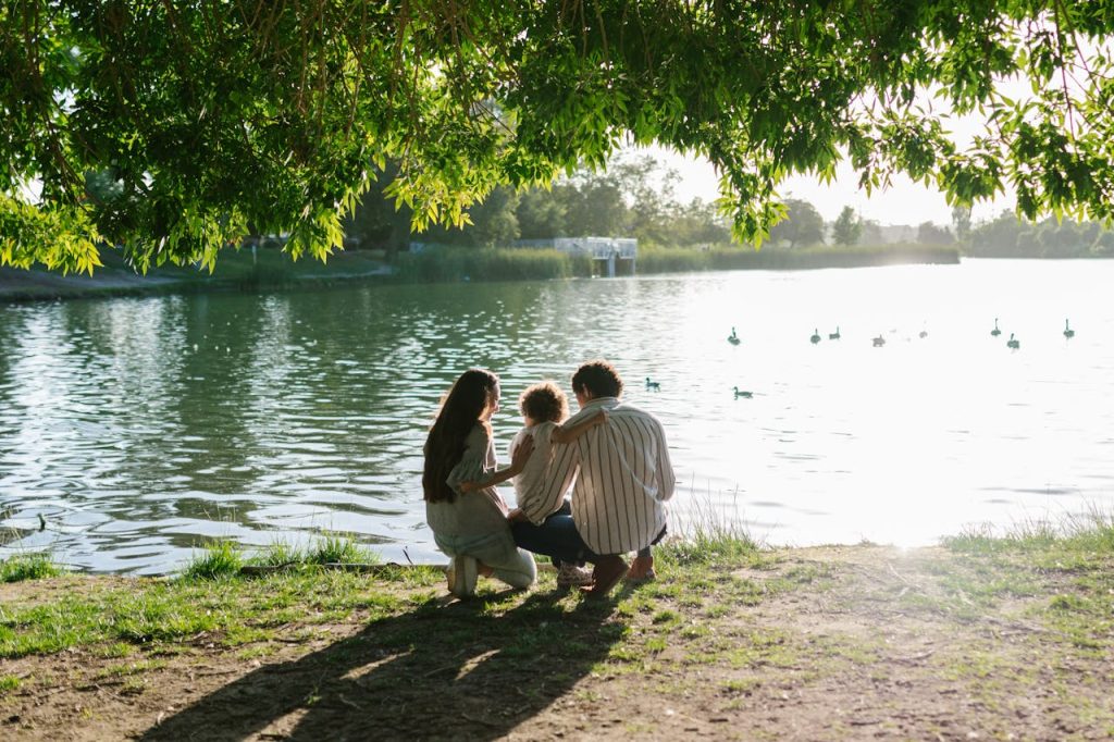 Man spending time with family by a lakeside, fully present and engaged, representing a fulfilling identity beyond work.
