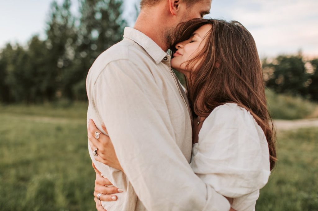 Couple embracing outdoors at sunset, sharing a tender moment that reflects mindful dating, emotional presence, and authentic connection.
