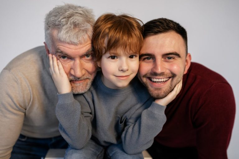Grandfather, father, and child smiling together, symbolizing healing across generations and the journey of forgiving your father.