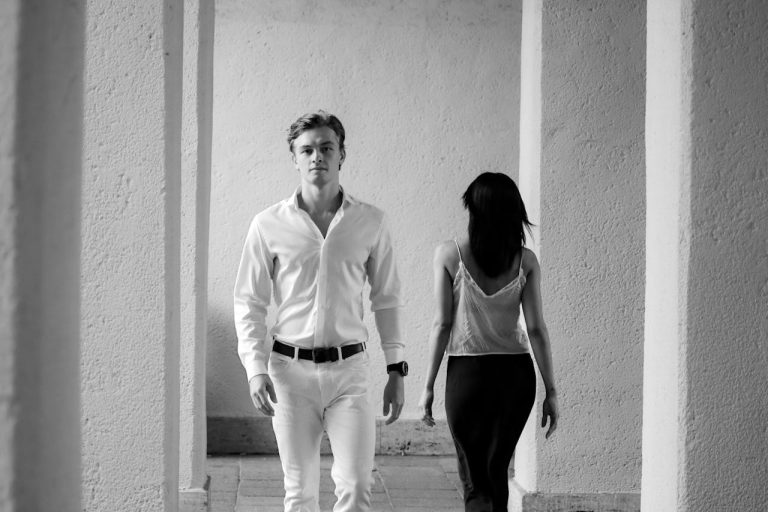 Man walking confidently past a woman without objectifying her, showing redefining manly strength through composure and respect.