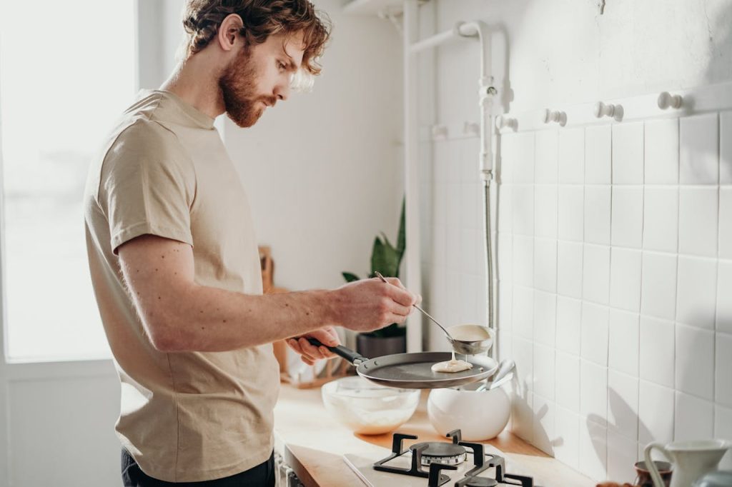 Man cooking a simple meal alone in a bright, peaceful kitchen.