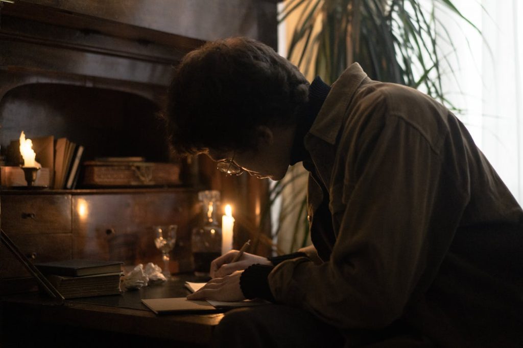 A man journaling alone at a desk by candlelight, representing emotional intelligence in men through self-reflection and emotional awareness.