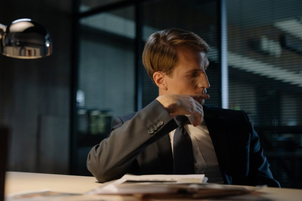 Man sitting alone in an office, looking stressed and withdrawn, representing workplace pressures tied to men’s mental health stigma.
