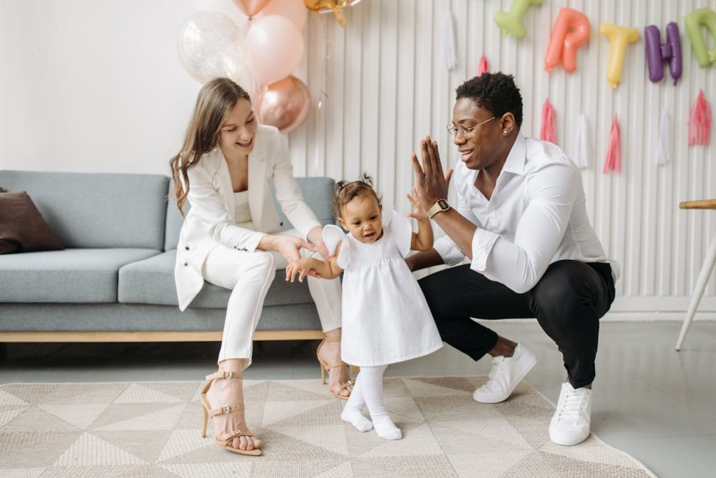 Father celebrating his toddler’s first steps with supportive joy, illustrating relational strength and redefining manly strength.