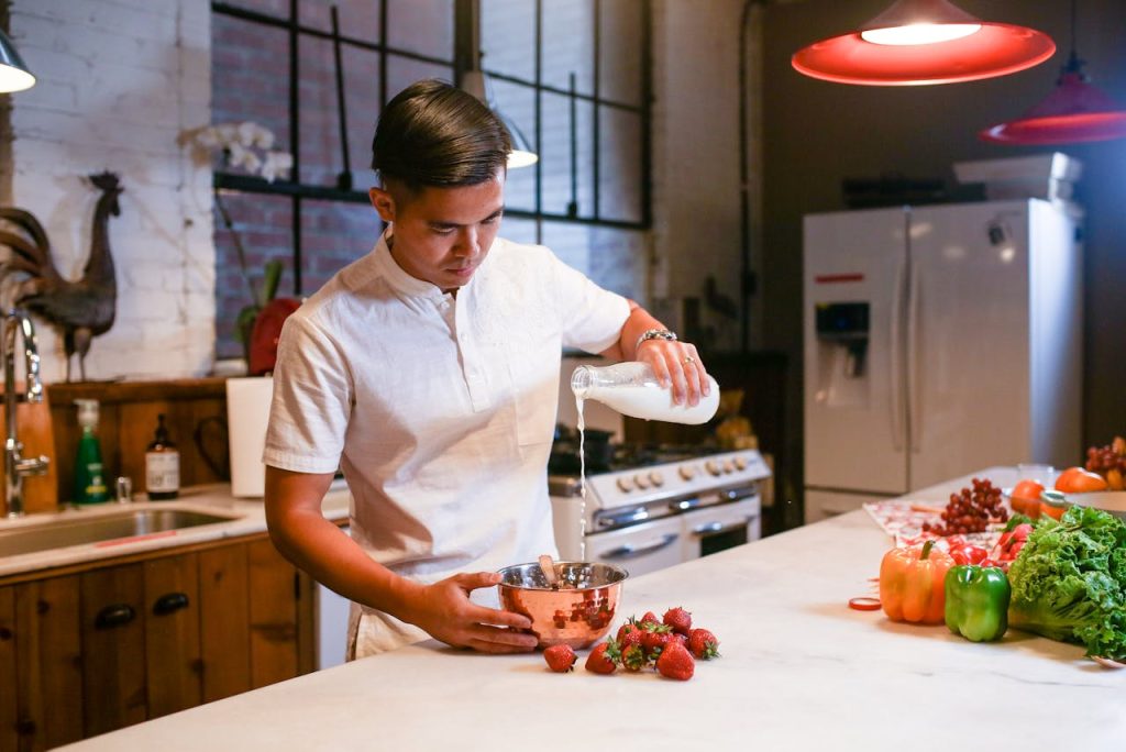 A man cooking in a home kitchen, carefully preparing ingredients, illustrating creative outlets for men through mindful cooking and hands-on creativity.