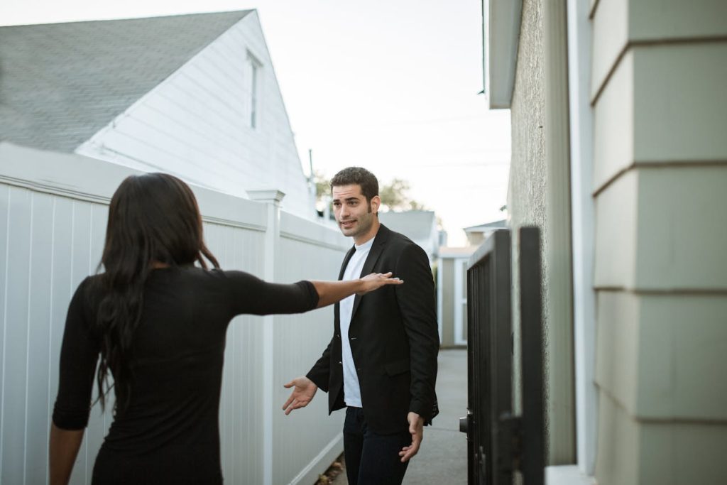 Couple arguing outdoors with the man appearing defensive and the woman setting a boundary, illustrating how machismo harms relationships.