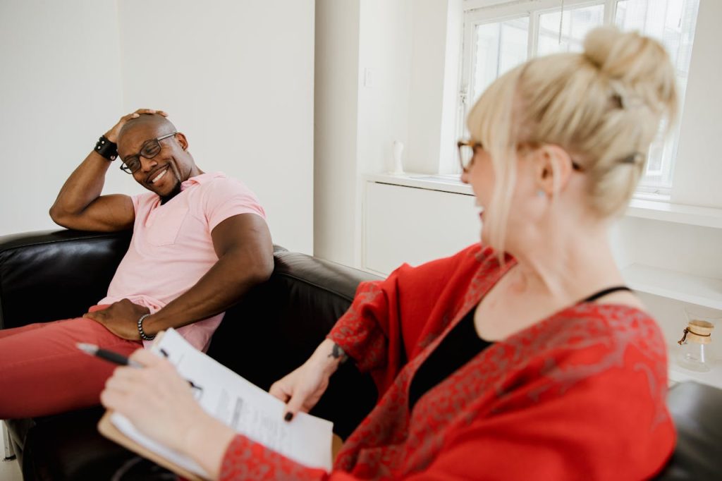 A man speaking thoughtfully with a therapist in a counseling session, illustrating healing and emotional growth in avoidant attachment in men.