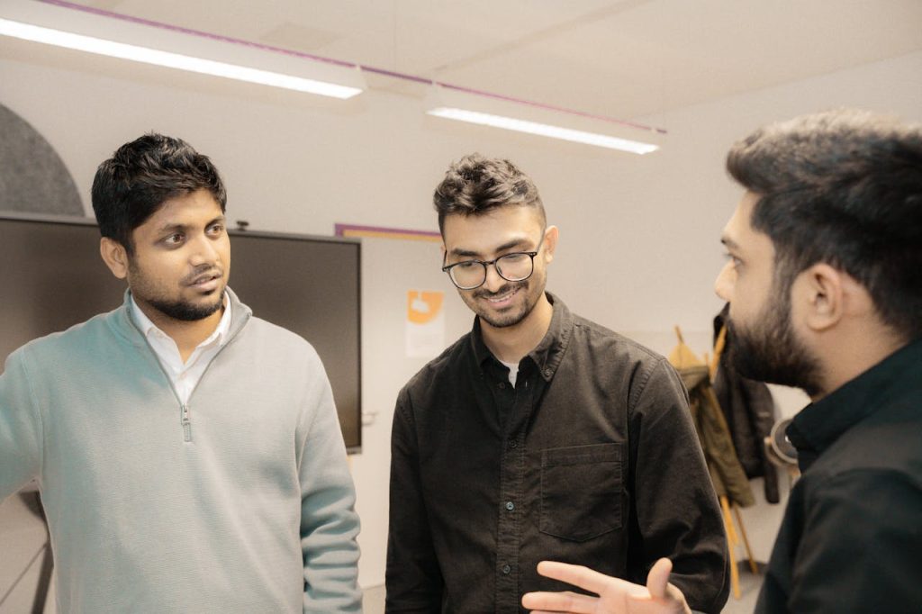 Group of men having a supportive, open conversation, illustrating mature masculinity and healthy peer connection.