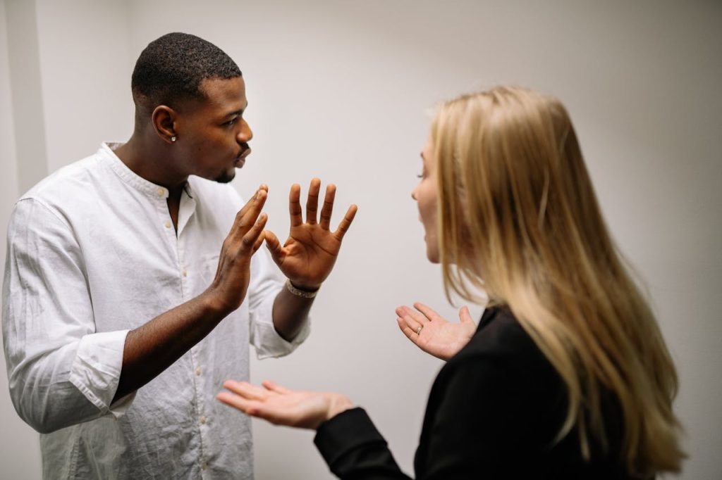 A man calmly communicating with his partner during a difficult conversation, demonstrating emotional intelligence in men through emotional regulation and respectful dialogue.
