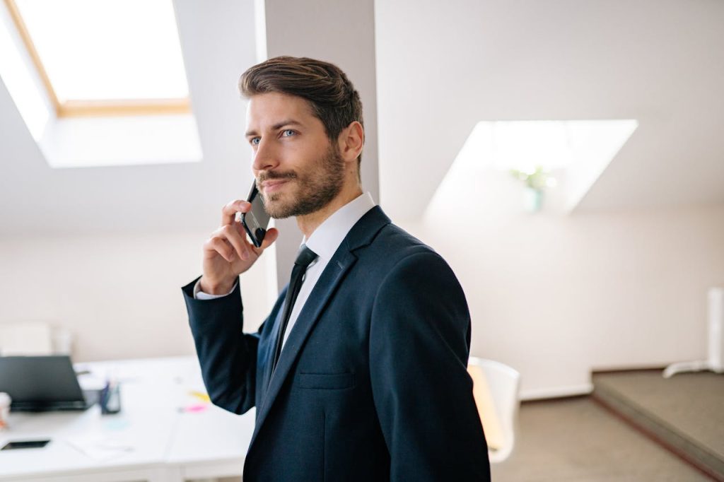A man speaking calmly on the phone with a relaxed expression, representing authentic self-expression beyond Nice Guy syndrome and approval-seeking behavior.