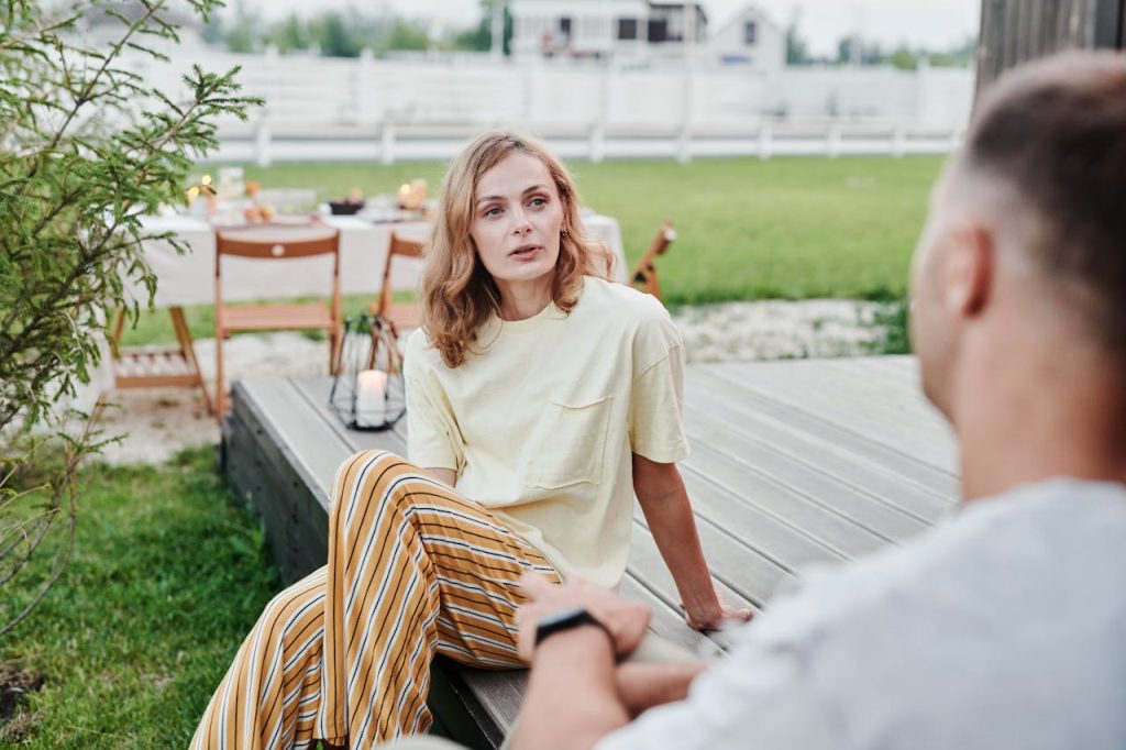 A couple sitting outdoors in focused conversation, illustrating communication in relationships through attentive listening and emotional presence.