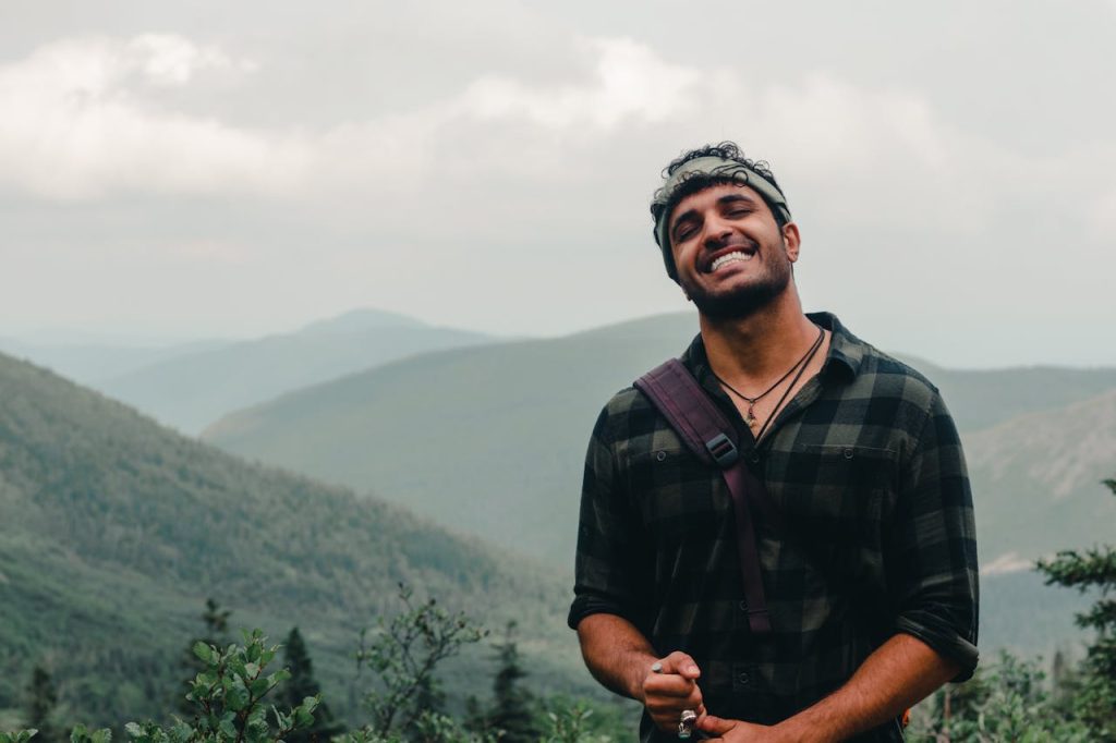 Man standing alone in nature with a relaxed expression, symbolizing overcoming the fear of being alone and learning to value one’s own company.