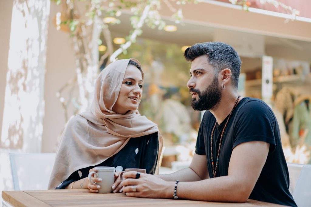 Couple having a calm, serious conversation over coffee, symbolizing open communication and shared priorities in a romantic relationship.