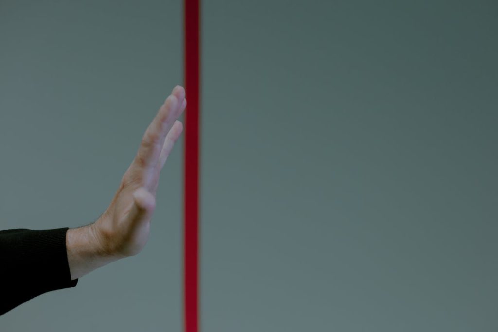 Man calmly raising his hand in a stop gesture, symbolizing healthy boundary-setting and self-respect.