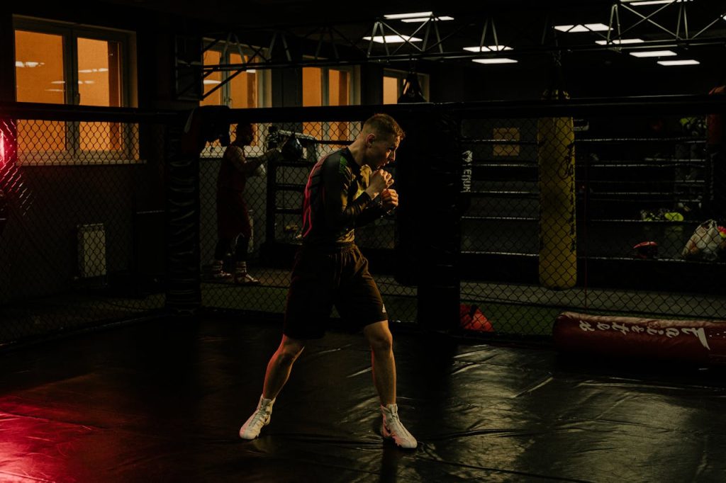 Man training alone in a boxing gym, focused and disciplined, symbolizing the cultivation of masculine energy through purpose and action.