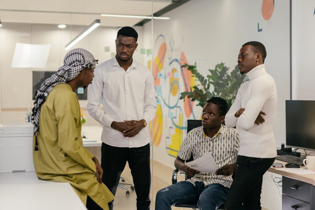 A man in a group meeting listening attentively while others speak, illustrating humility as strength through openness, restraint, and respect for others’ perspectives.