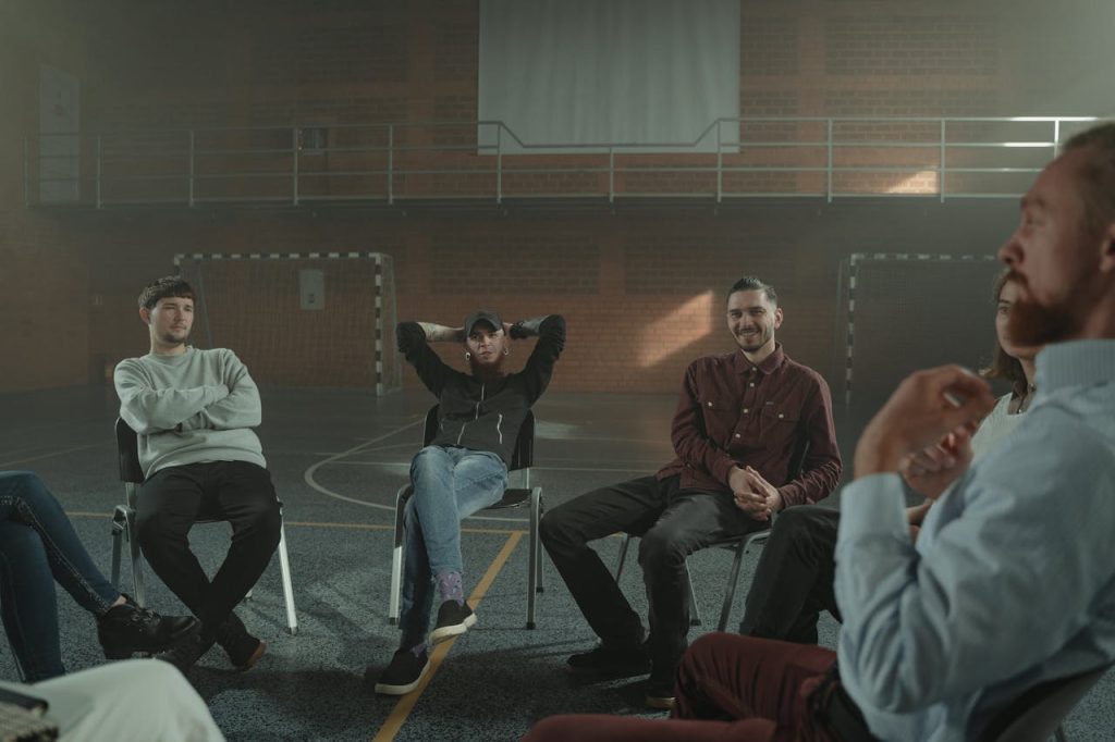 A group of men sitting in a circle and talking openly, illustrating peer support and collective healing from childhood trauma in men.